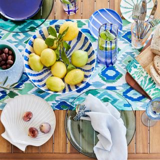 Sea-inspired tableware set serving lemons and fruit on wooden tabletop