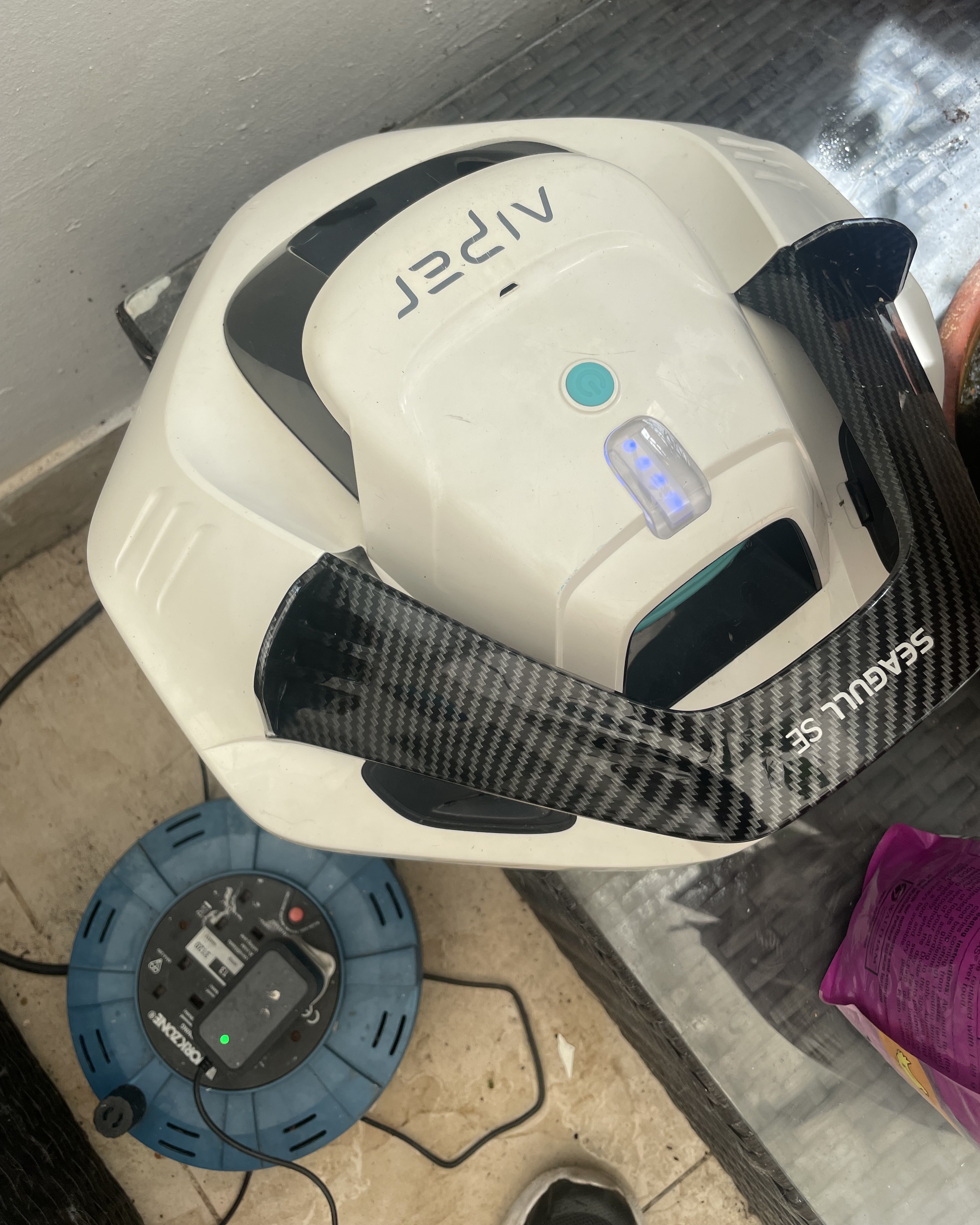 An Aiper robot pool cleaner being charged