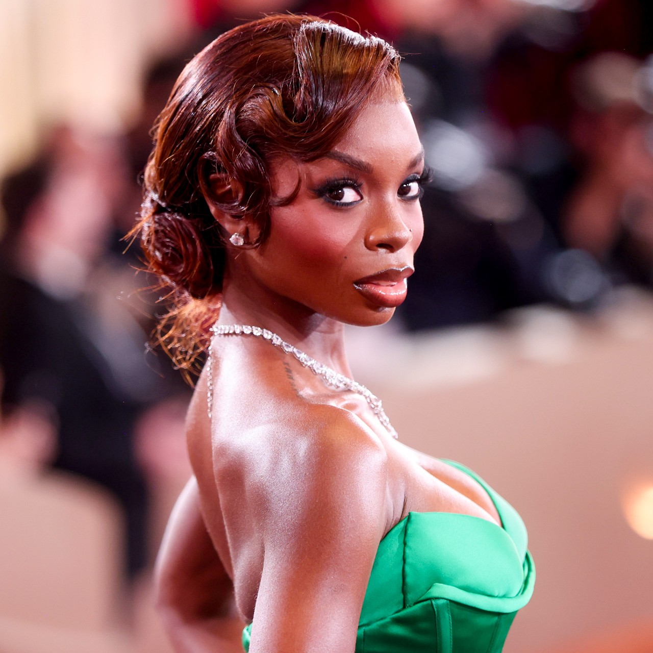 a black woman with red hair poses for a photo at a red carpet event