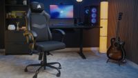 A Corsair TC80 gaming chair in a room next to a gaming PC, desk, and guitar.