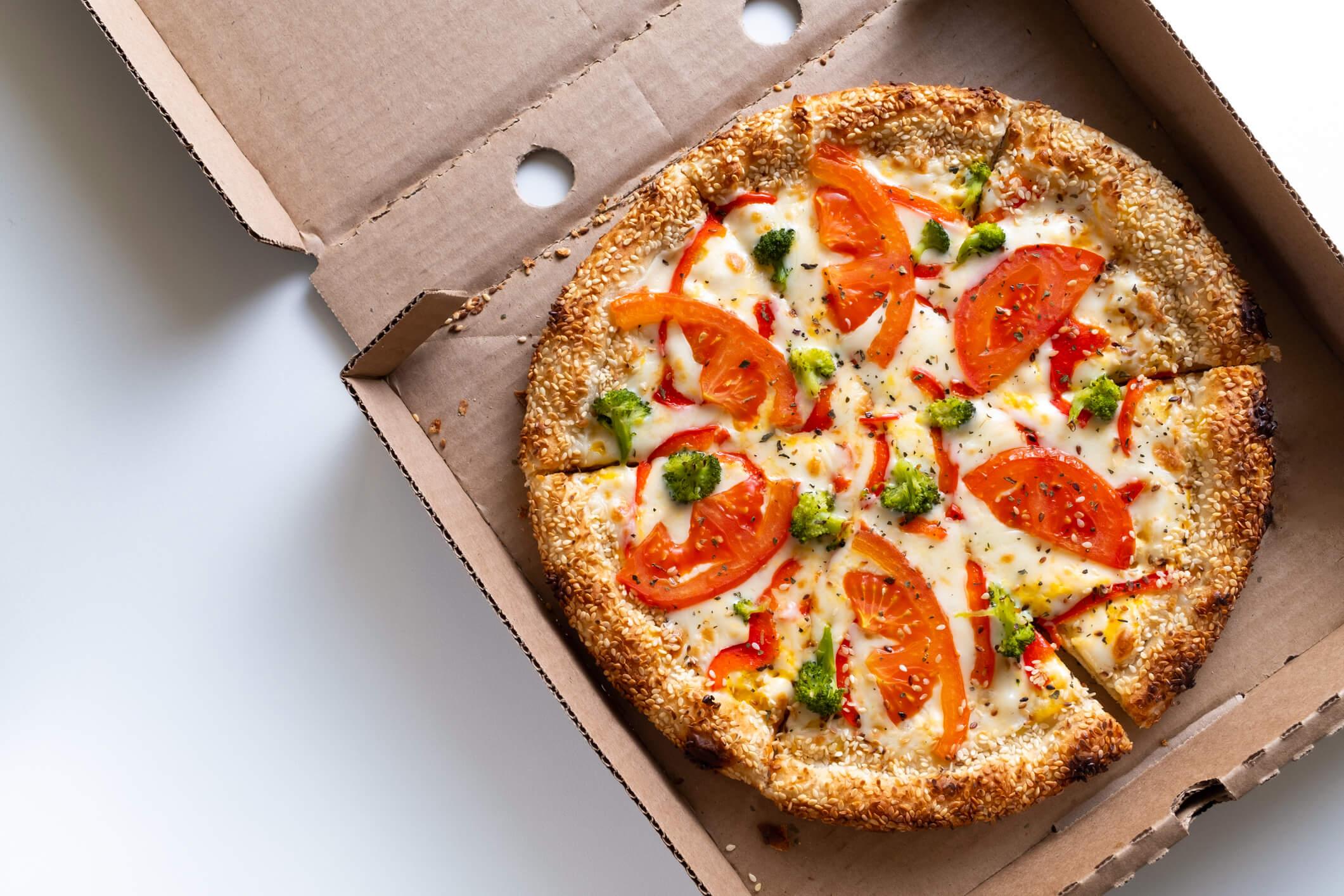  Italian pizza in a pizza box and for delivery, on a white background or table. Pizza Margarita with tomatoes and cheese and broccoli, without meat. The concept of vegetarian food, fast junk food.  