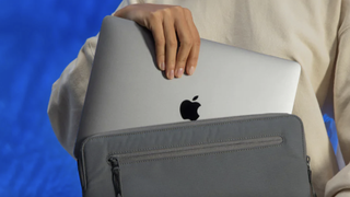 someone putting their macbook into an Incase BIONIC MacBook sleeve