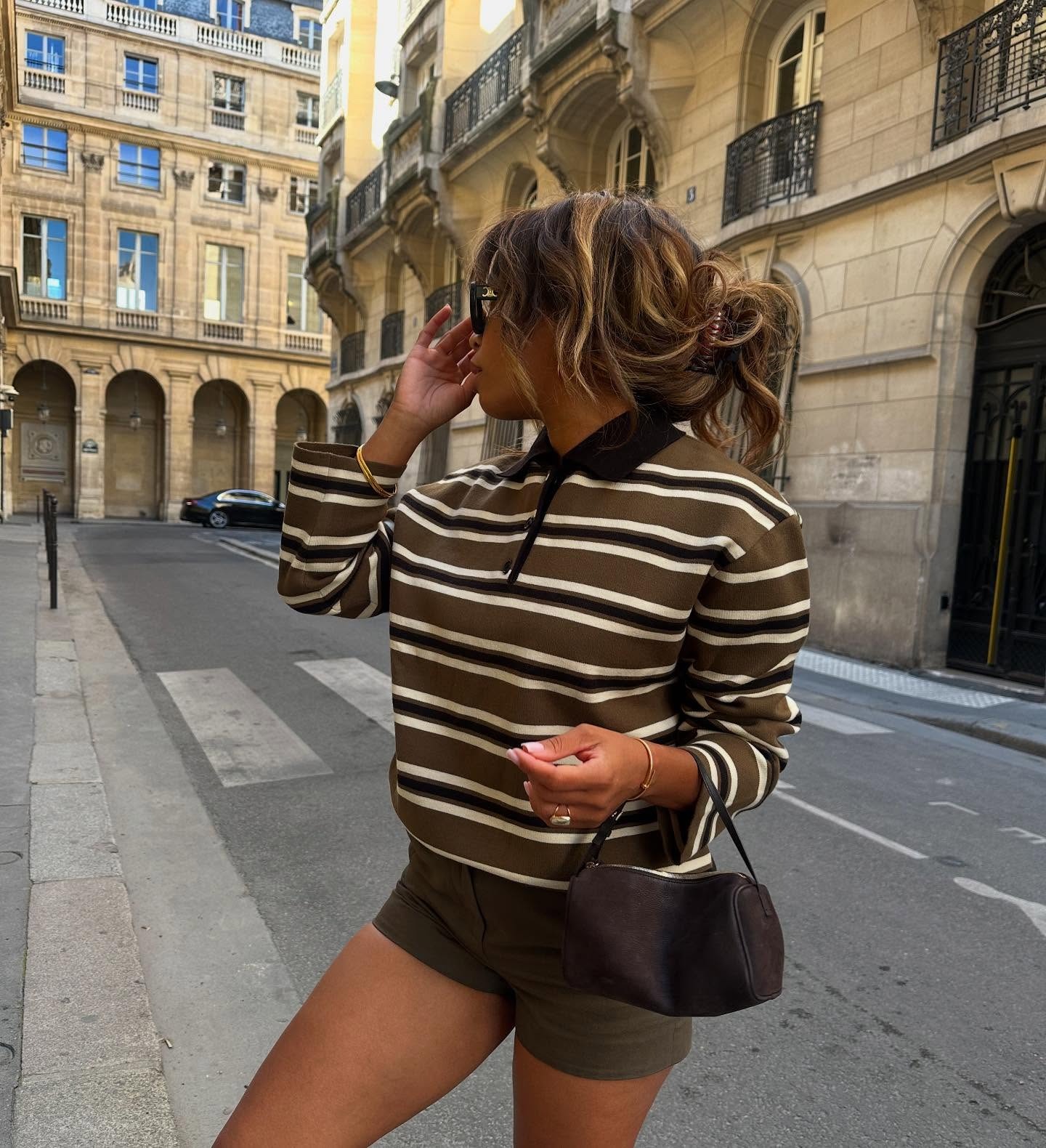 French woman wearing a striped polo shirt and shorts