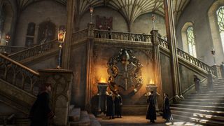 Hogwarts Legacyn Tylypahkan pääaula soihtujen valossa, kaksi oppilasta kiipeämässä portaita