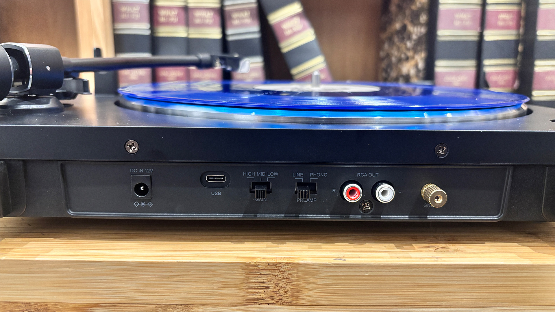 Sharp RP-TT100 Bluetooth turntable in front of bookcase, rear of turntable showing connectio