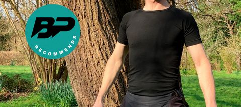 Man wearing short-sleeved base layer in front of tree