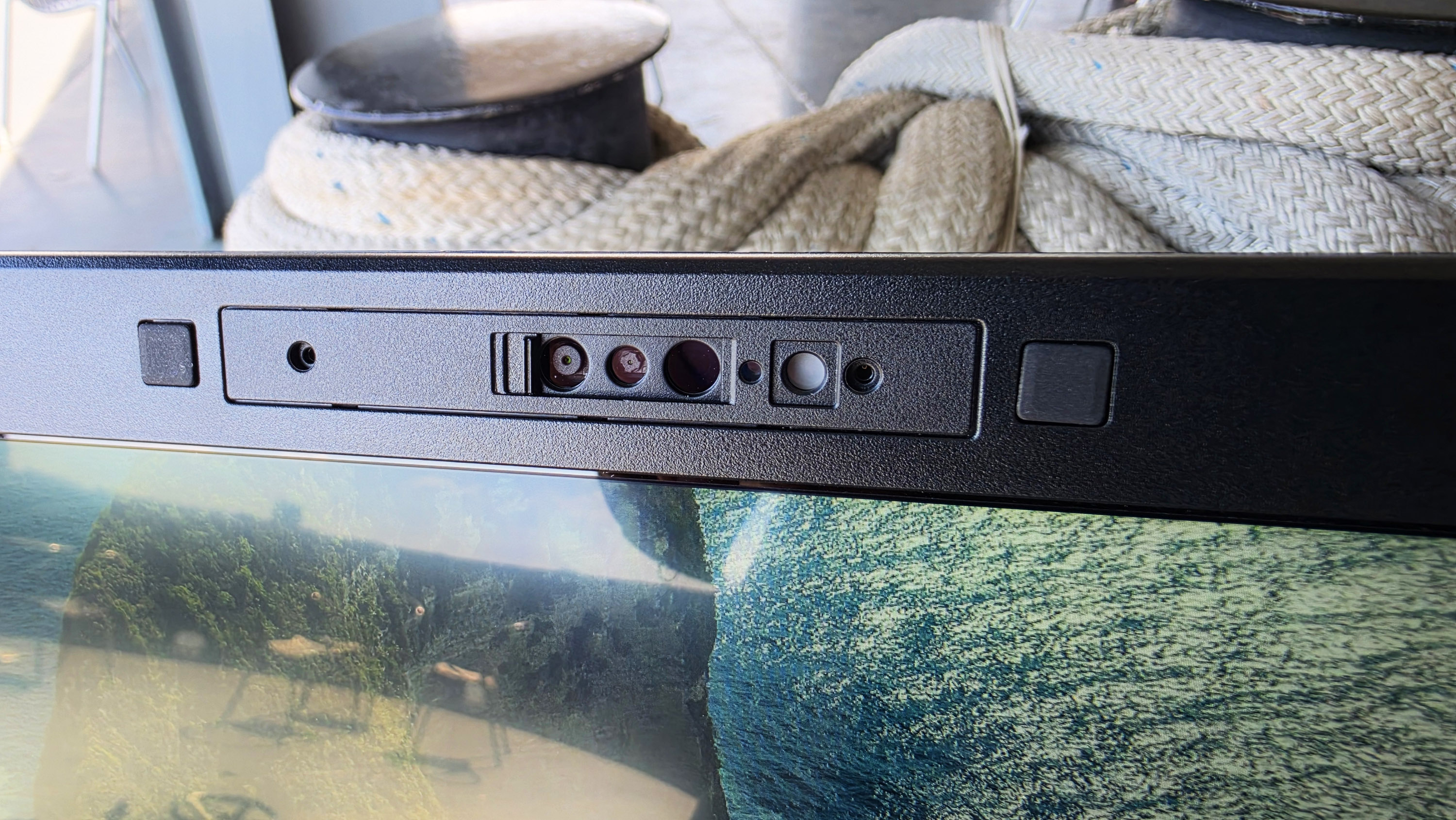 Close-up of a Toughbook 56 webcam showing various buttons and dials against a backdrop of coiled rope. The scene conveys a nautical theme.