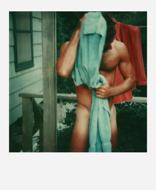 Man stood naked holding a towel