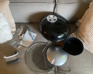 Weber Smokey Joe BBQ contents and parts on grey sofa