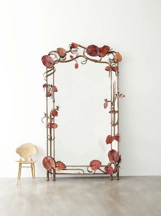 A mirror frame with beautiful decorations next to bamboo chair