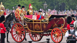 Prince William and Kate Middleton riding in their wedding carriage