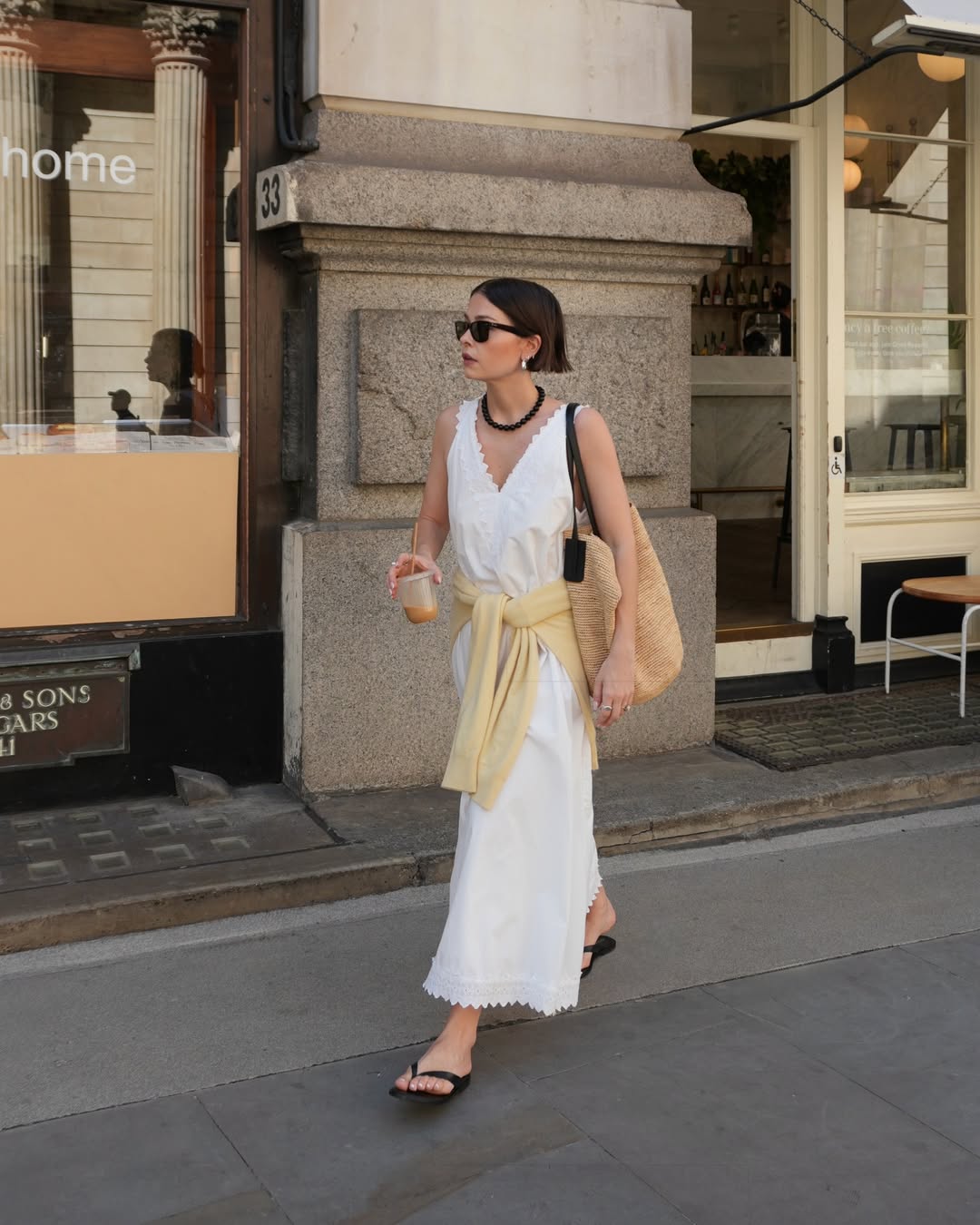 Influencer Alice Satterthwaite wearing a white maxi dress and pastel yellow jumper.