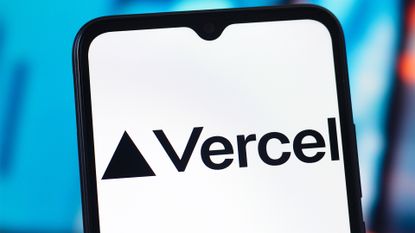 Logo and branding of cloud development platform Vercel pictured on a smartphone screen with blurred multi-colored background.