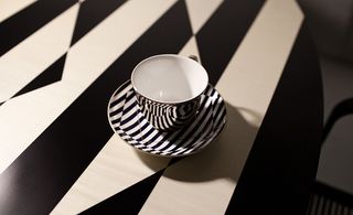 Black and white patterned tea cup and saucer on a black and white patterned table