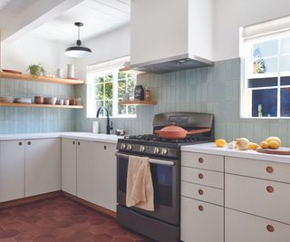 Kitchen with glazed brick tiles on the wall and antique terracotta hexagon tiles on the floor