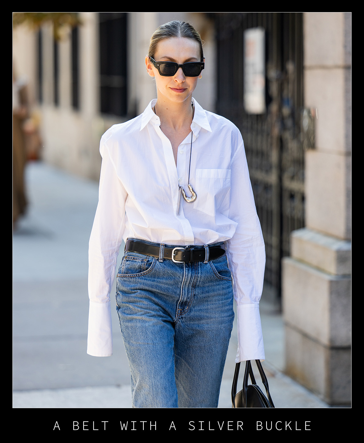 Woman in white shirt, jeans, and a black belt.