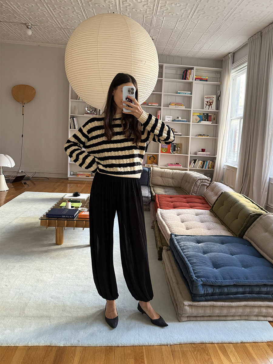 Melanie Masarin Ghia Founder Mirror Selfie at Home Wearing Striped Sweater, Jogger Pants, and Kitten Heels