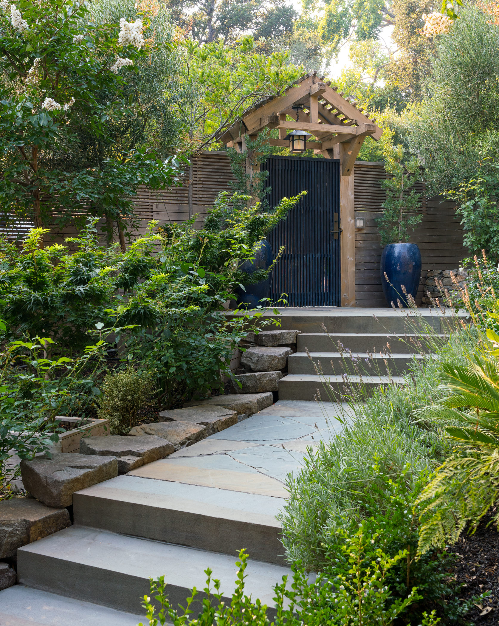A painted garden door in a garden with lots of greenery