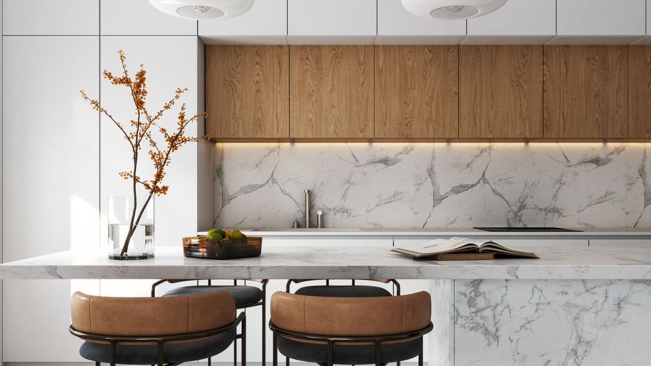 Luxury white kitchen with marble countertop and backsplash and leather stools with two pendant lights above island