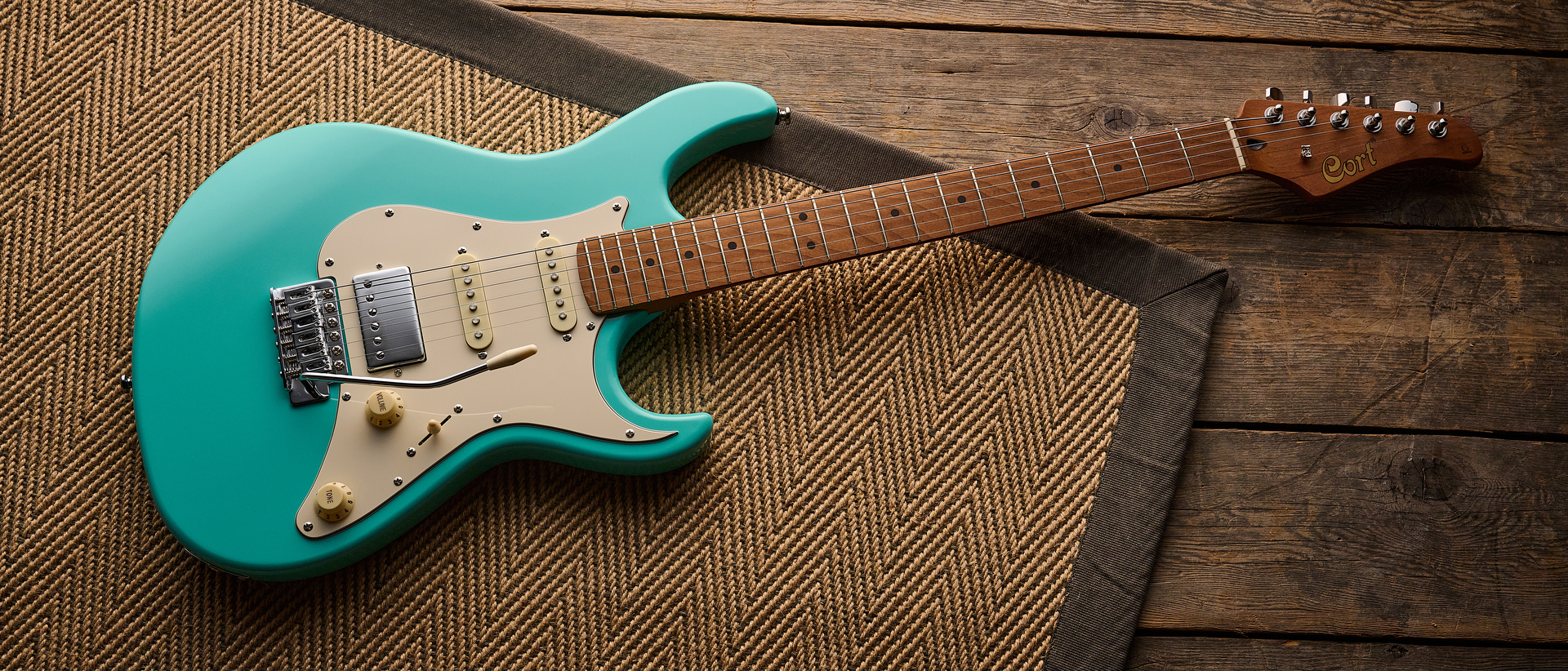 A Cort G200SE electric guitar lying on a rug