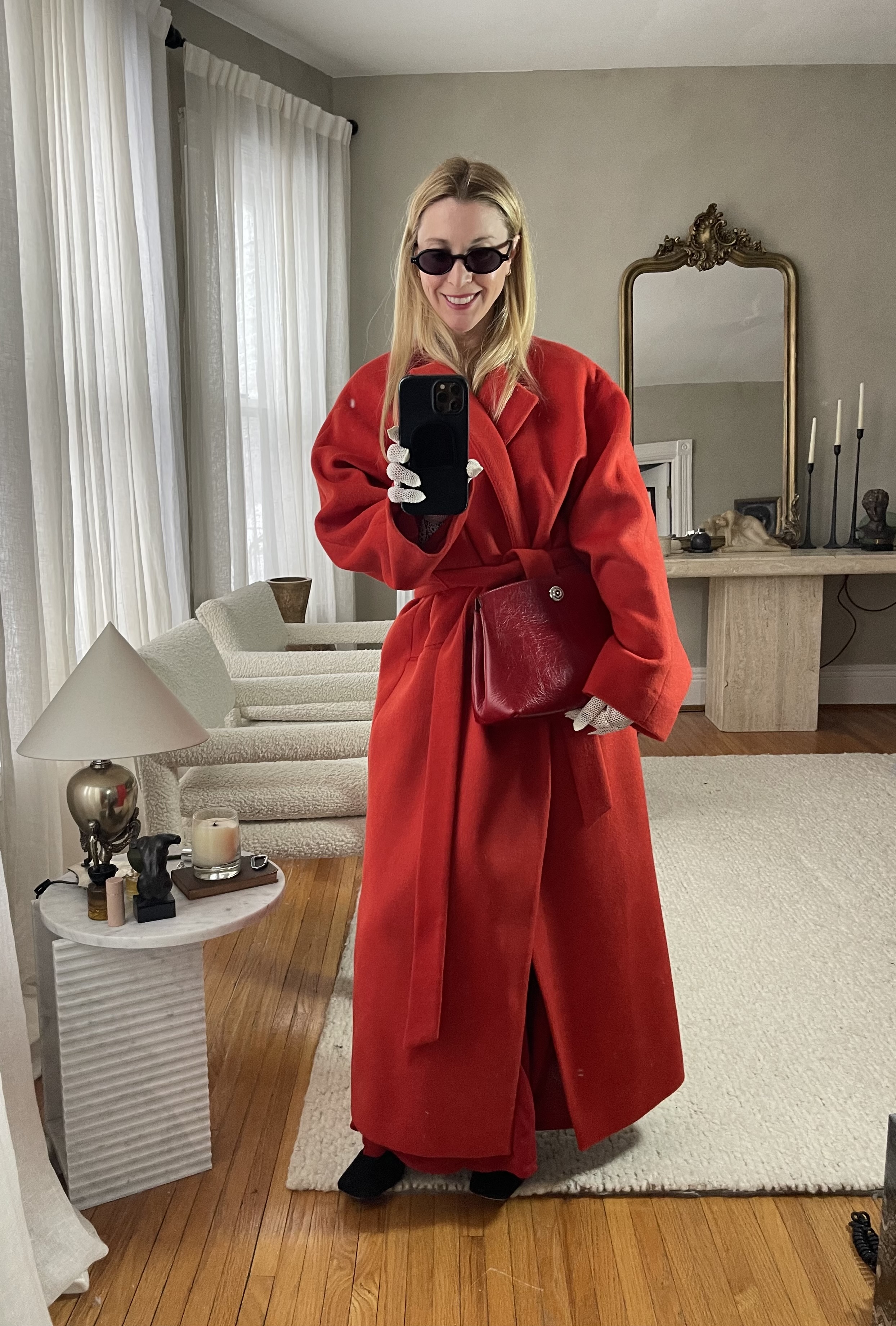 Kerry Pieri wearing a red coat, black shoes, and a red clutch