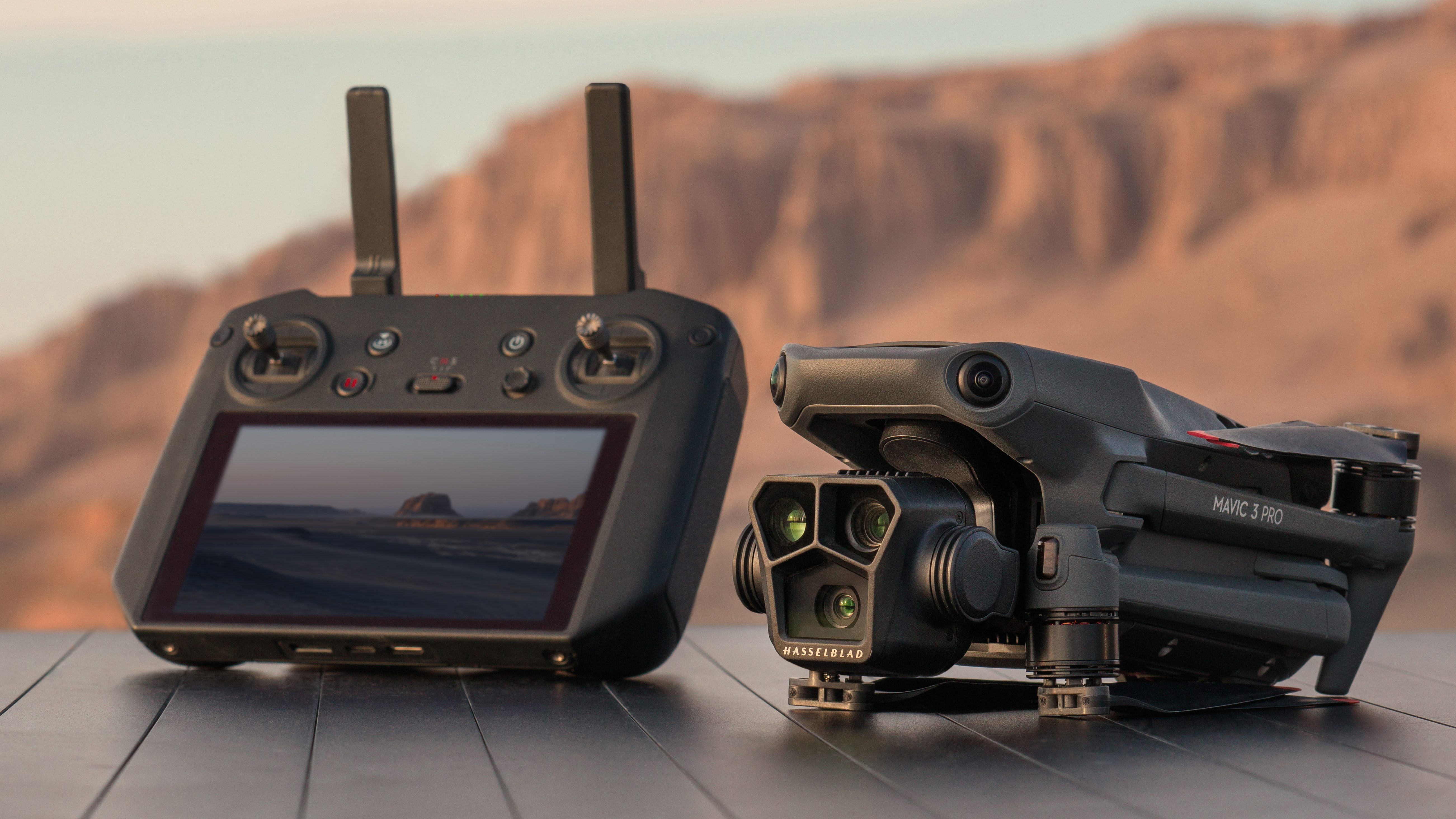 El dron DJI Mavic 3 Pro sentado sobre una roca junto a su controlador