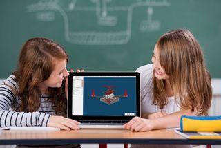 Two girls look at laptop computer display.