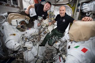 NASA astronaut Andrew Morgan (left) and European Space Agency astronaut Luca Parmitano work inside the Quest airlock to check their spacesuits and tools before beginning a series of spacewalks to repair the Alpha Magnetic Spectrometer.