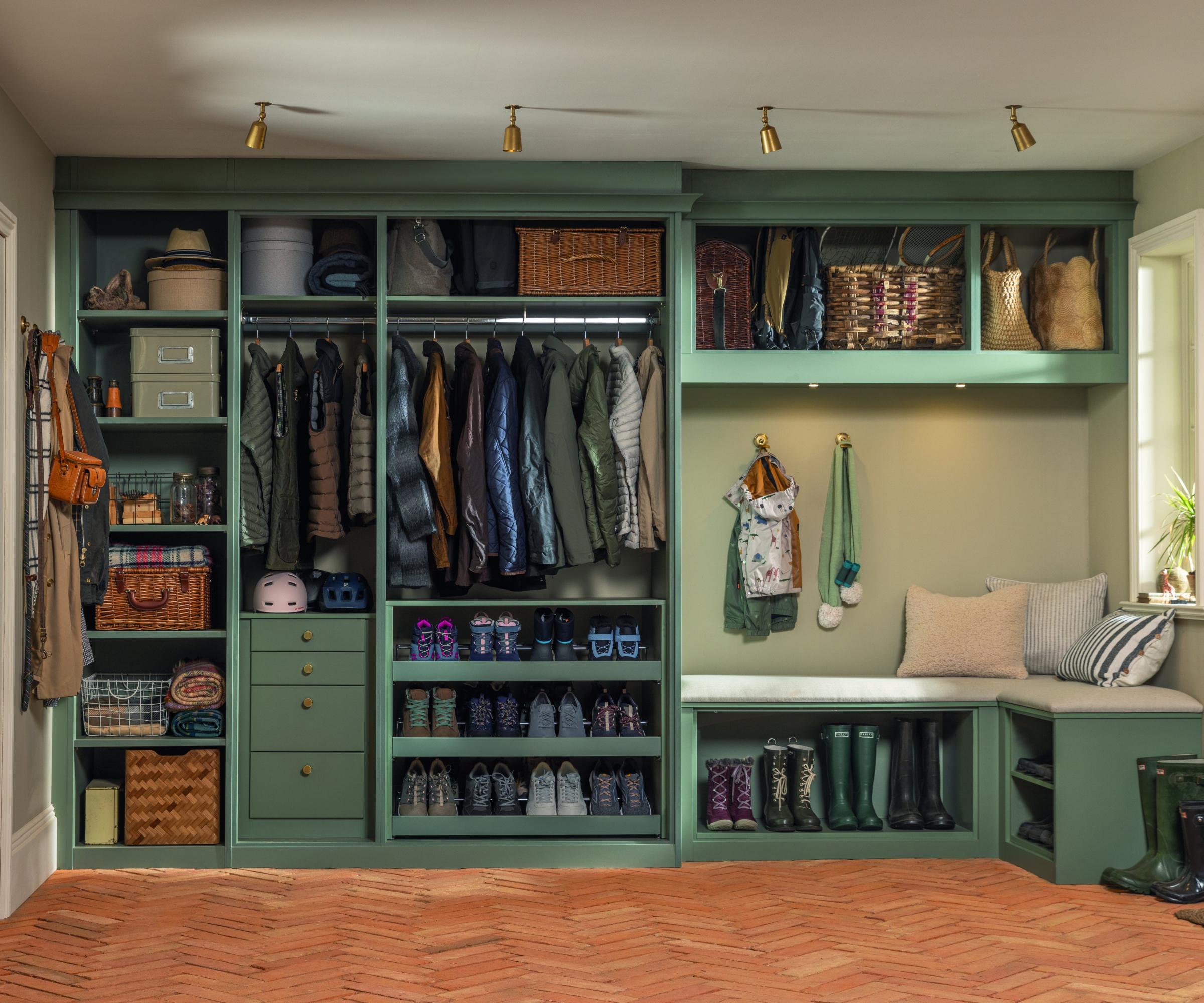 boot room with green built in storage housing shoes, coats, baskets and with built in seating area