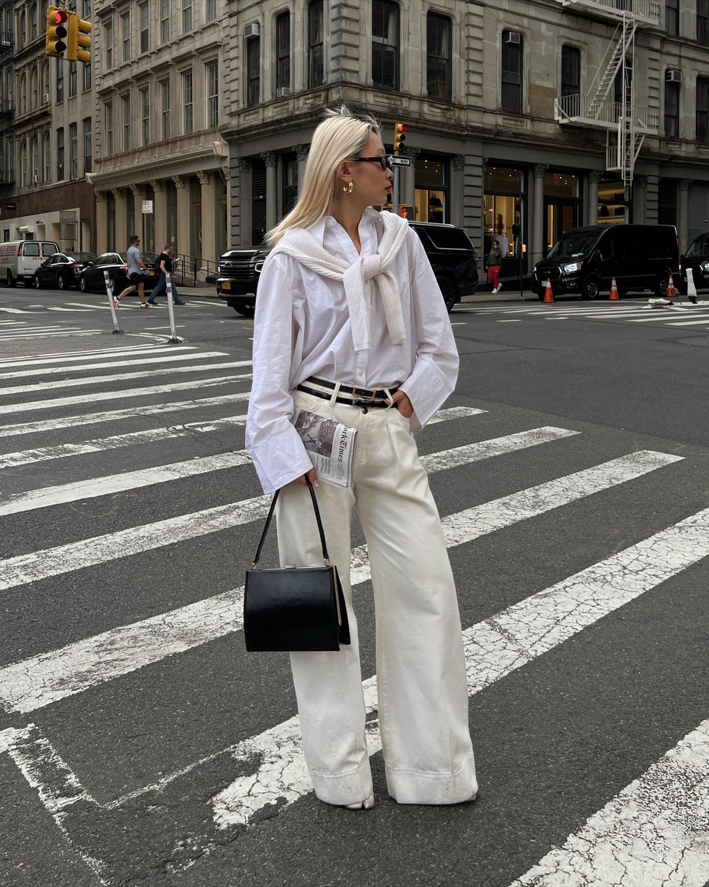 A woman wearing cream jeans and a white shirt with creamy blonde hair