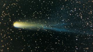 image of Halley's comet with yellow white body and a long yellow and blue tail.