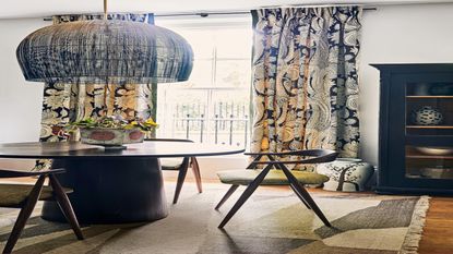 grey and gold curtains in a wooden floored room with a black table