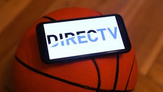 A phone with the DirecTV logo balanced on a basketball.
