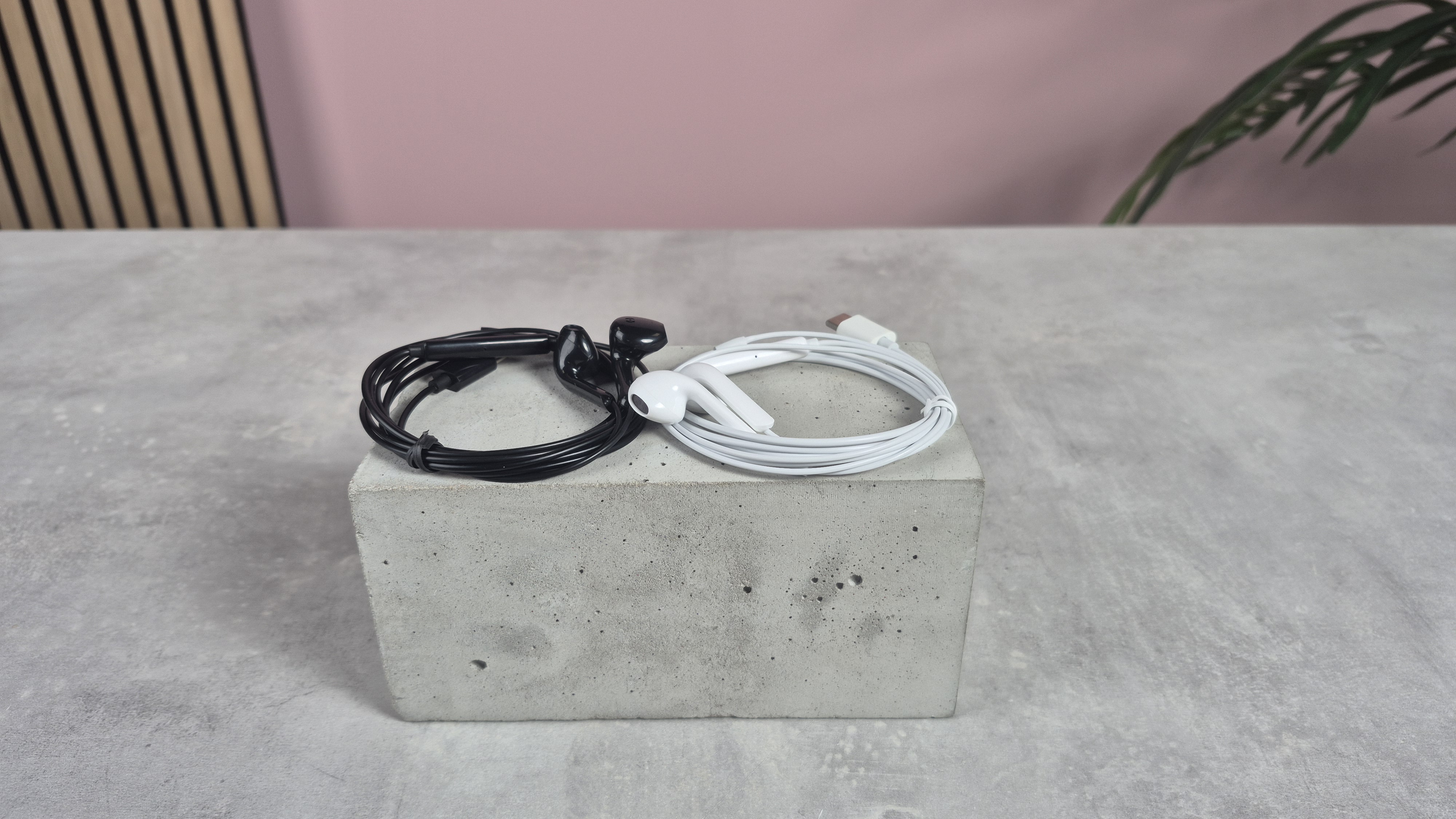 ZJXD wired earbuds on block against pink background