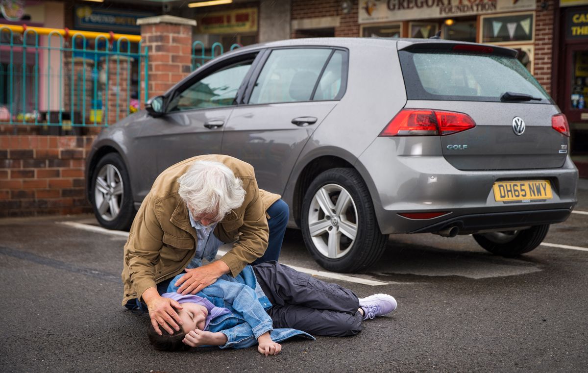 Stu cradles Eliza Woodrow in the street.