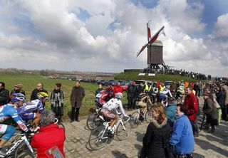 Crowds line a section of cobbles.