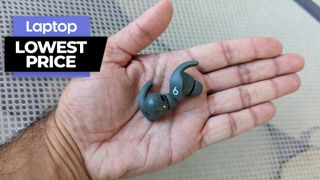 Man holding gray Beats Fit Pro wirelss earbuds in palm