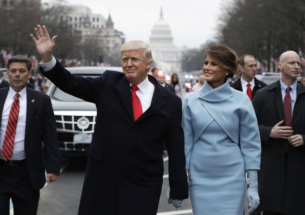 U.S. President Donald Trump waves while walking with U.S. First Lady Melania Trump, during a parade following the 58th presidential inauguration in Washington, D.C., U.S., on Friday, Jan. 20, 2017