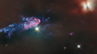 The Hubble Space Telescope captured two young stars named HOPS 150, which glows a bright golden red in the upper-right corner of the image, and HOPS 153, which lies on the left side of the image, represented by a narrow, colourful jet, in the Orion Nebula. 