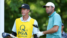 Scottie Scheffler speaks to his caddie
