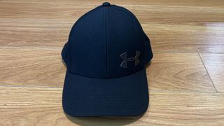 White under armor hat, hole in back for pony tail. See pics. Black logo