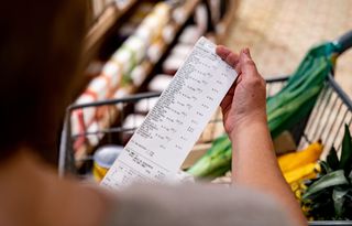 Close-up on a woman looking at a receipt after shopping at the supermarket