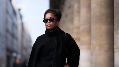 glycerin - woman wearing sunglasses and a black winter coat - gettyimages 1779065815