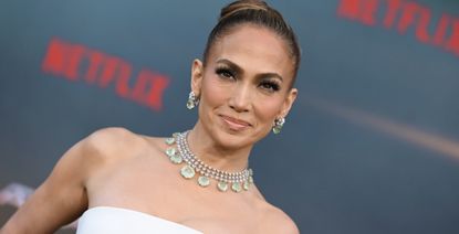 jennifer lopez at a netflix premiere wearing a white top and skirt