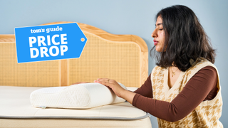 Woman assessing a white Tempur-Neck curved pillow