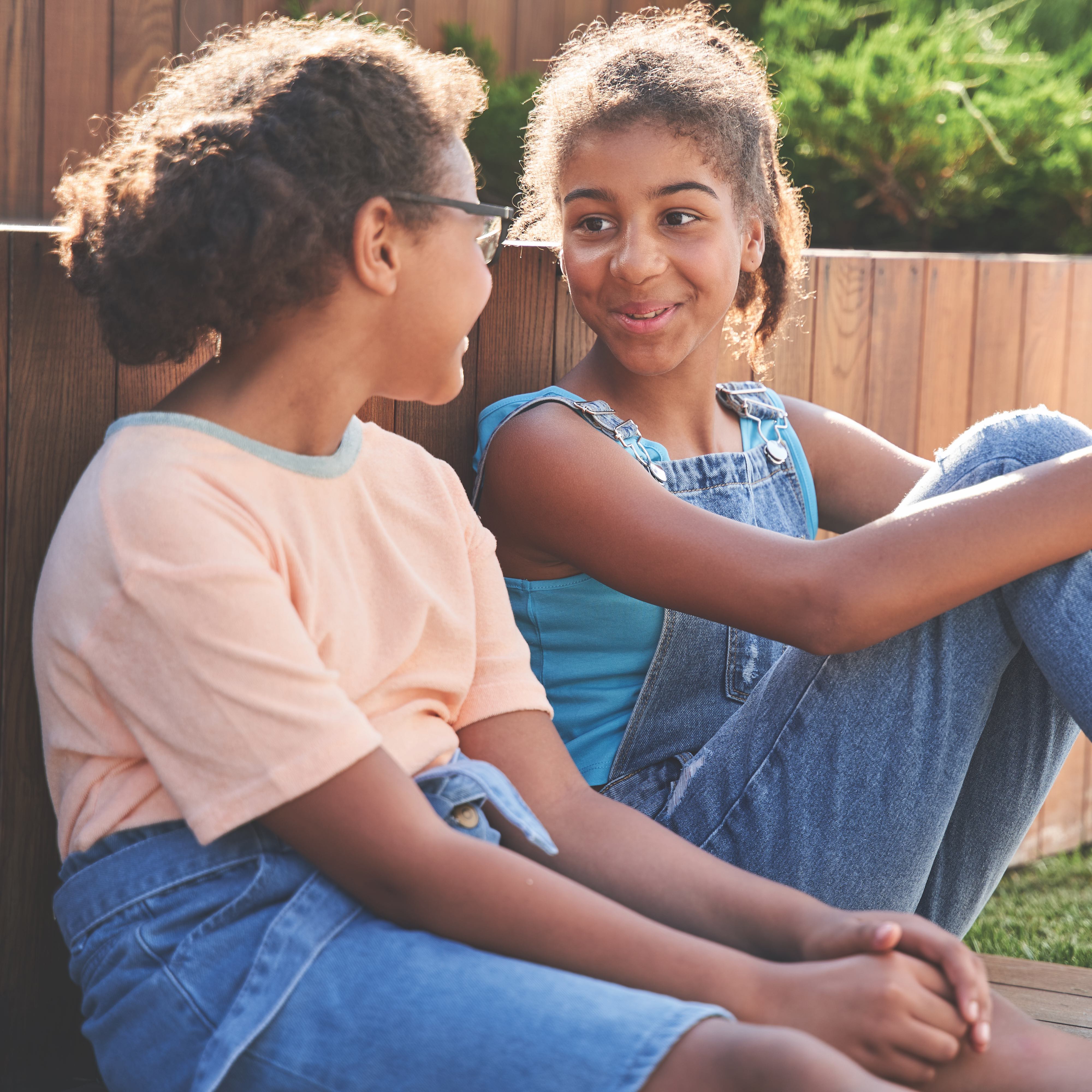 Two girls talking to each other in a garden