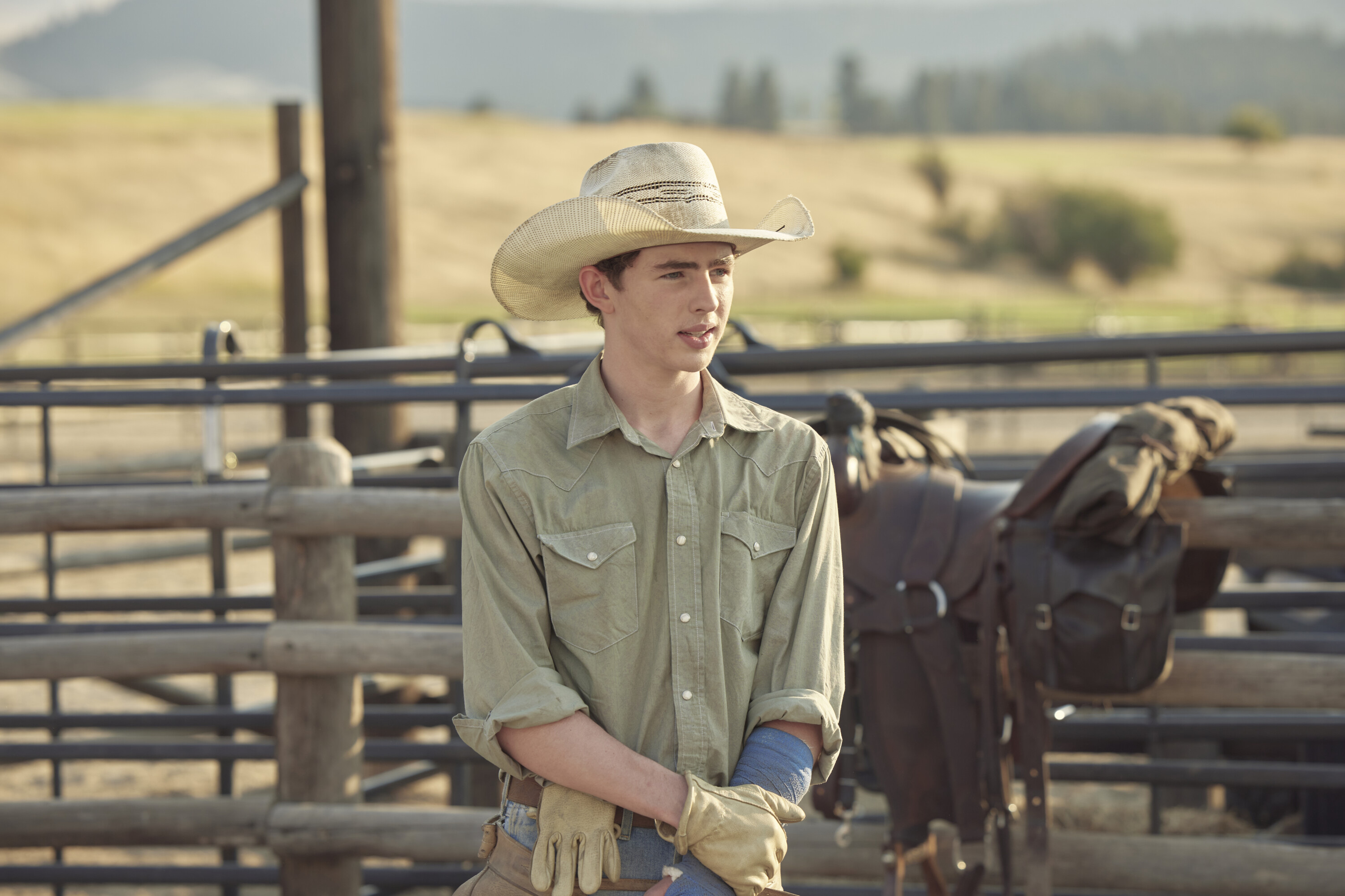 Finn Little, who plays Carter standing outside in a cowboy hat.