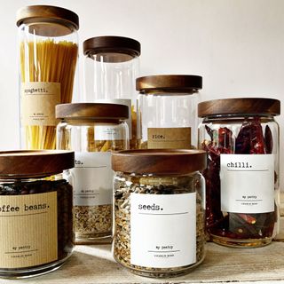 glass storage jars with wooden lids and labels to show how to organise a kitchen in style