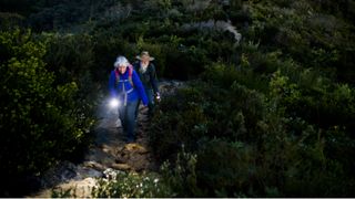 Woman and man trekking with a flashlight