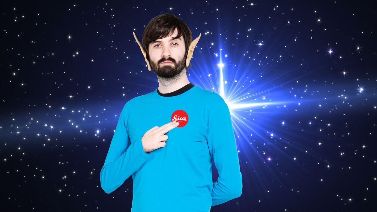 Man dressed as Mr Spock, with a Leica logo on his chest, in front of a starfield with &quot;warp point&quot;